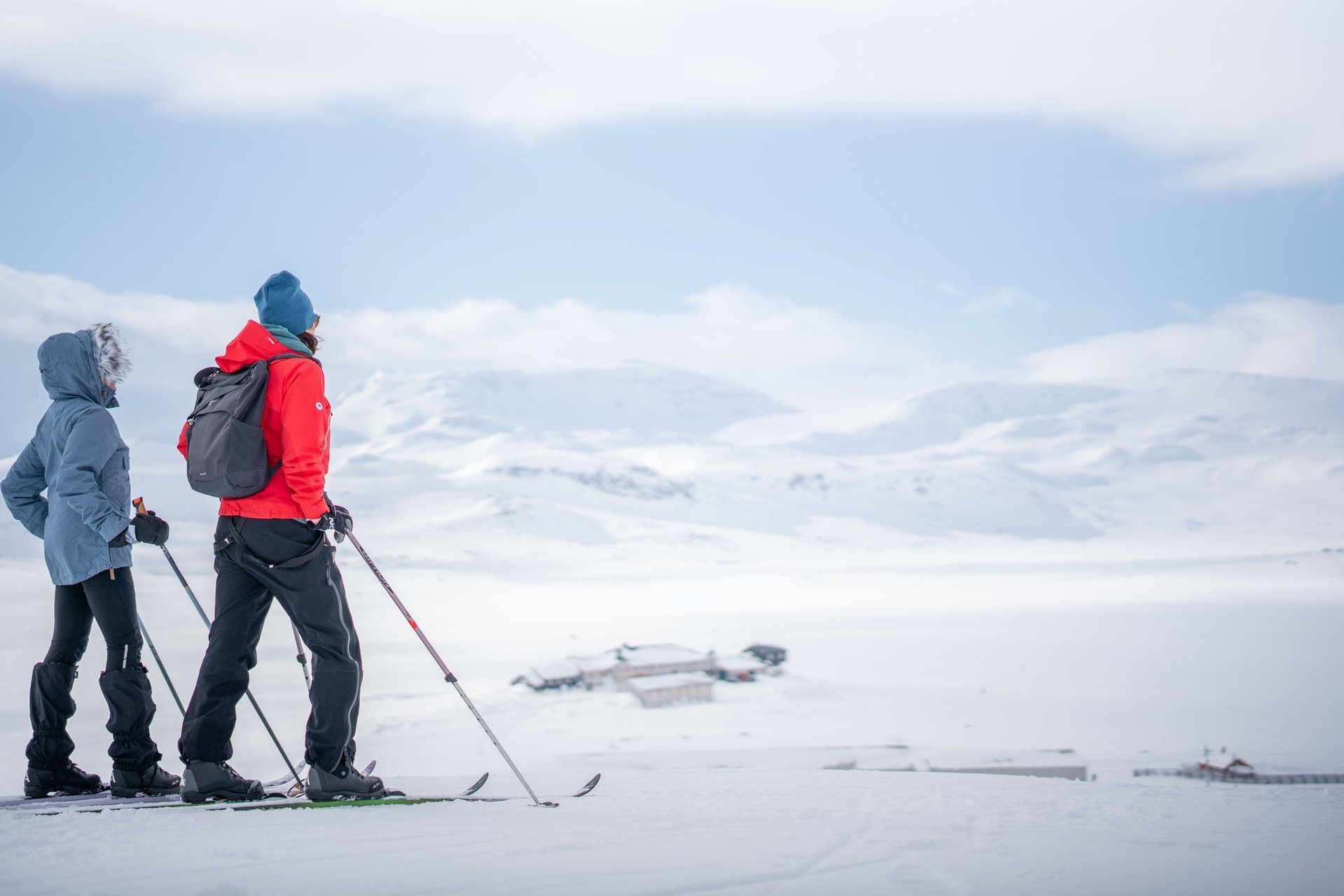 Langläufer mit Blick auf eine Hütte auf der Hardangervidda - Norwegen