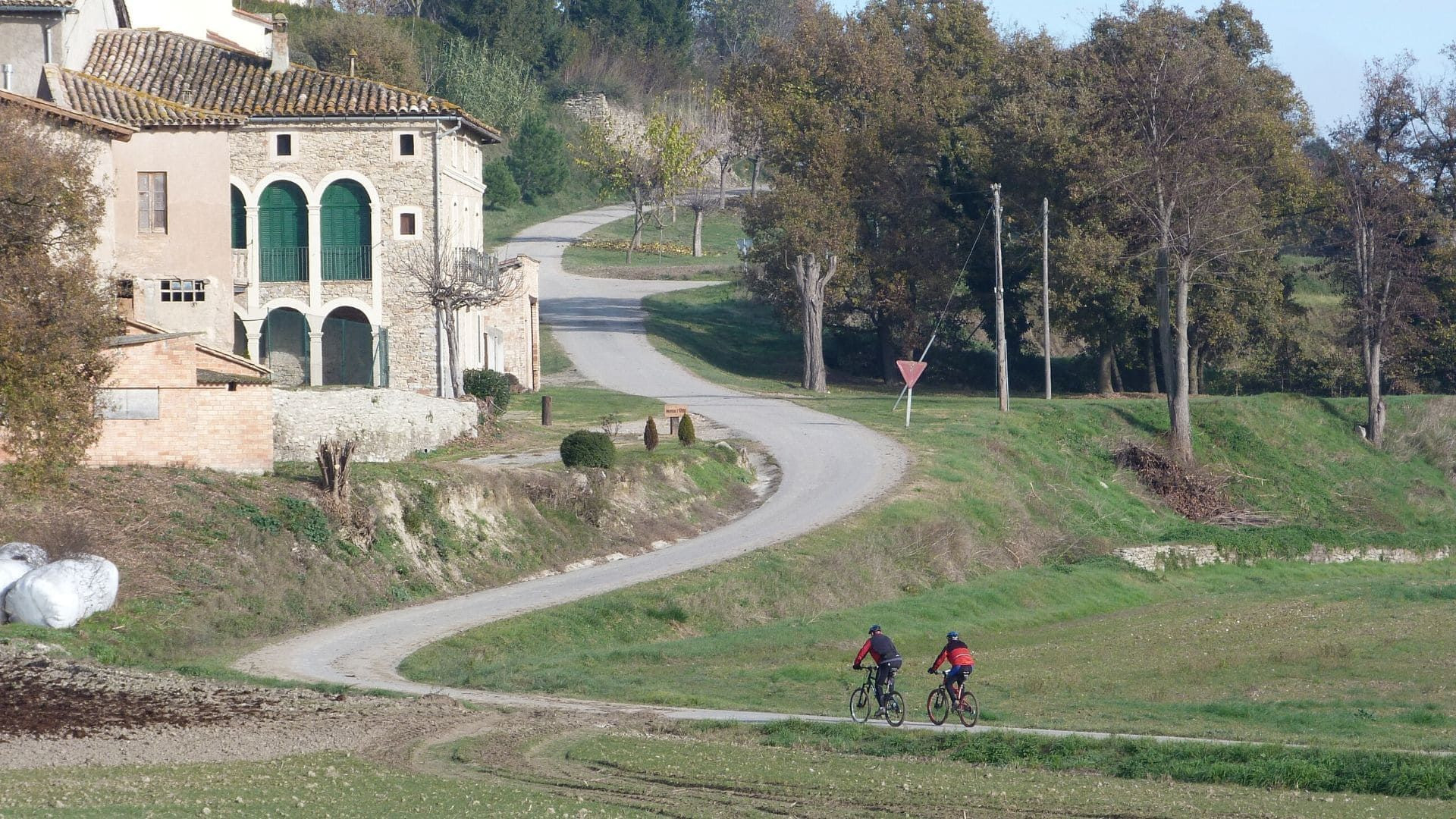 Radfahrer auf einer Landstraße nahe einem Bauernhaus - zwischen Vic und Barcelona - Katalonien - Spanien