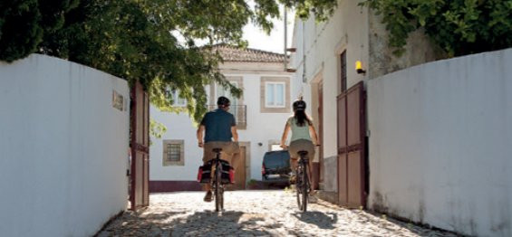 Radfahrer in einer weiß getünchten Gasse - Dourotal - Portugal