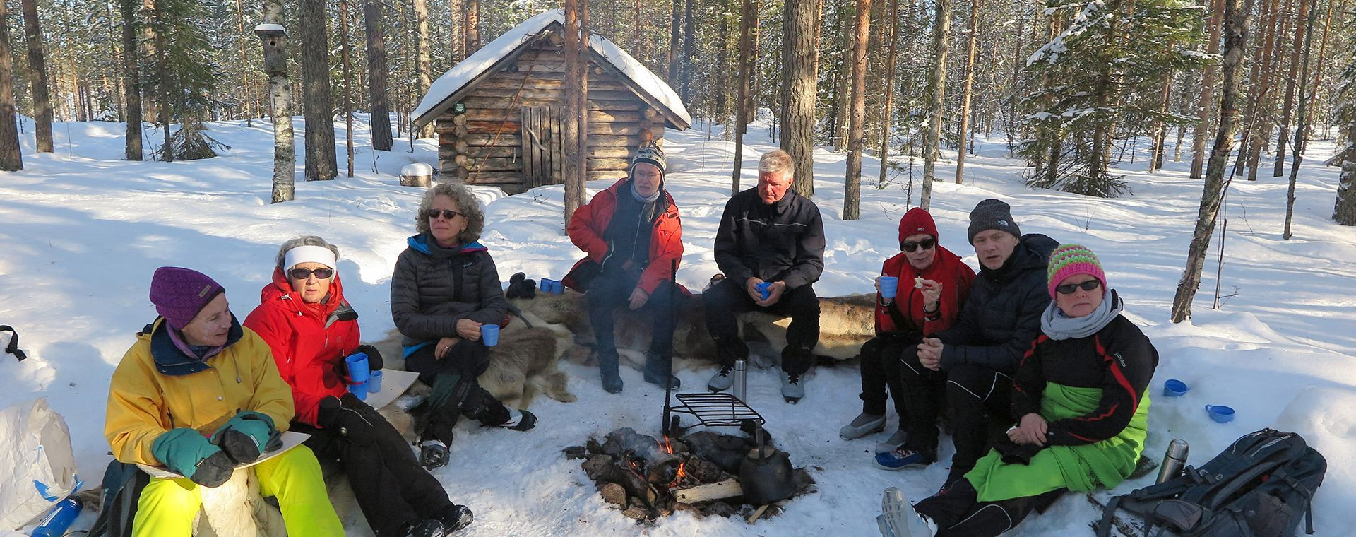 Pause autour du feu dans la forêt enneigée - Laponie - Finlande