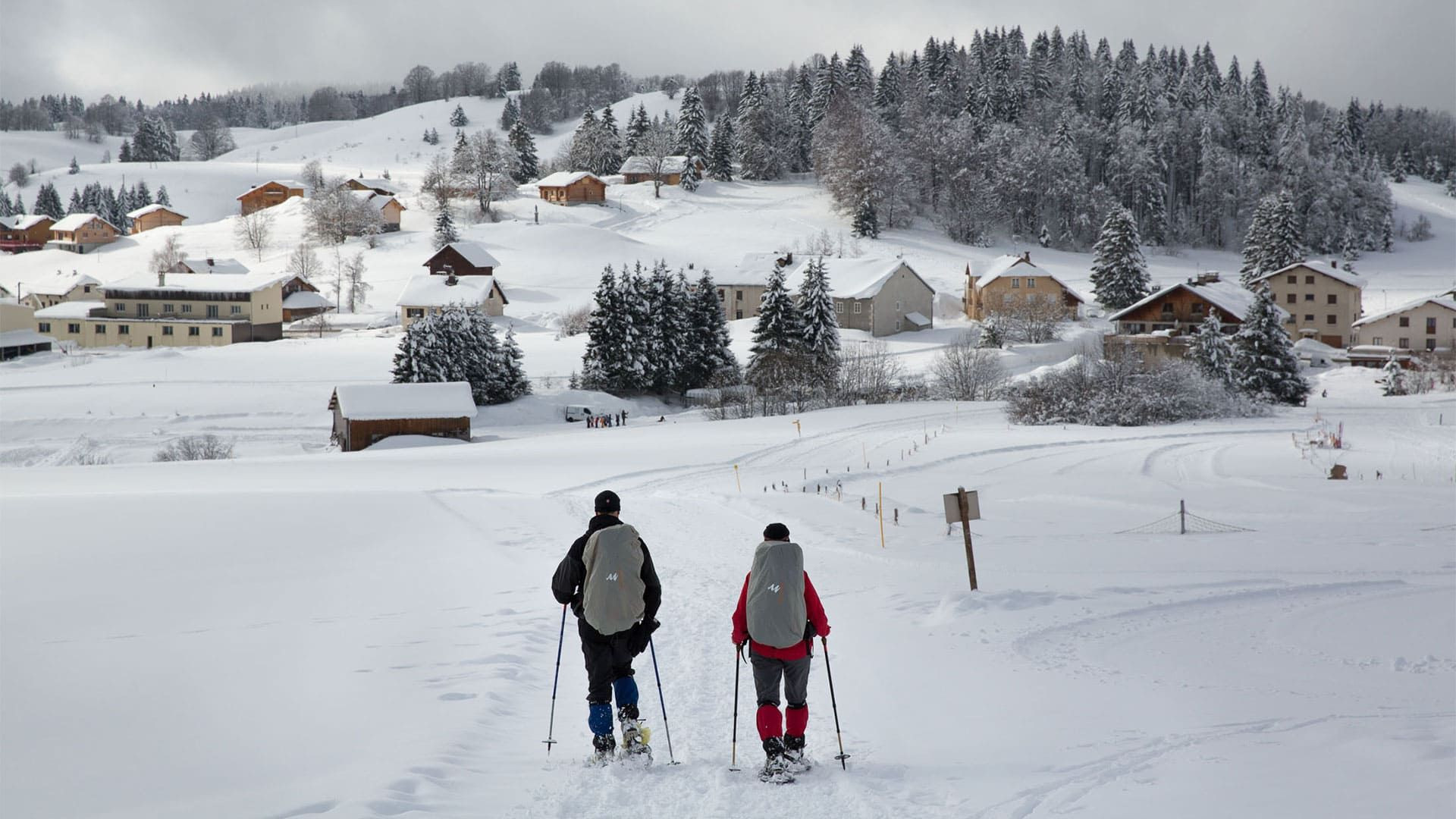 © Lex Van Den Bosch Schneeschuhwanderer oberhalb eines Dorfes - Grande Traversée du Jura - Frankreich