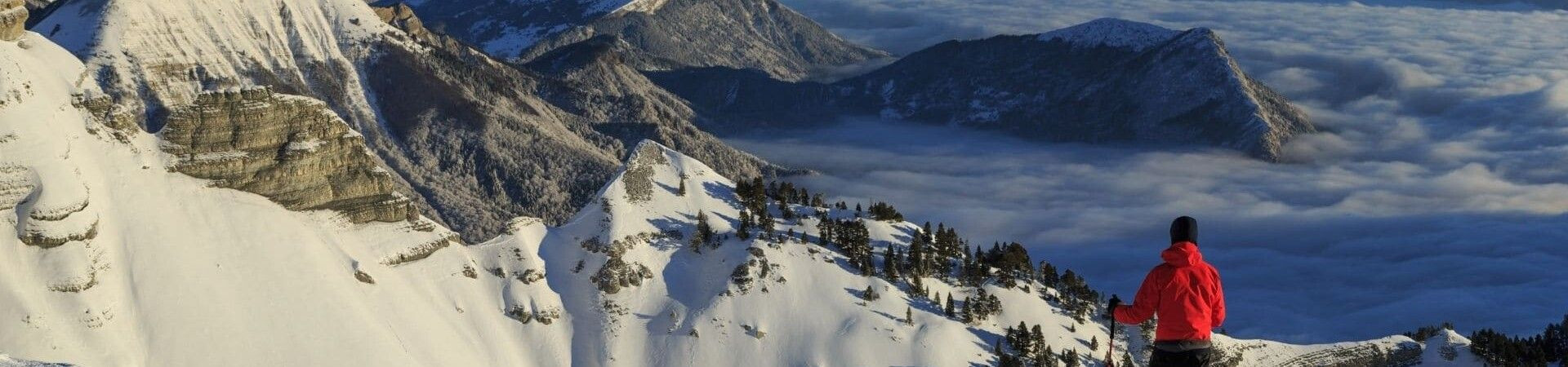 Wanderer betrachtet verschneite Gipfel über einem Wolkenmeer - Vercors - Frankreich