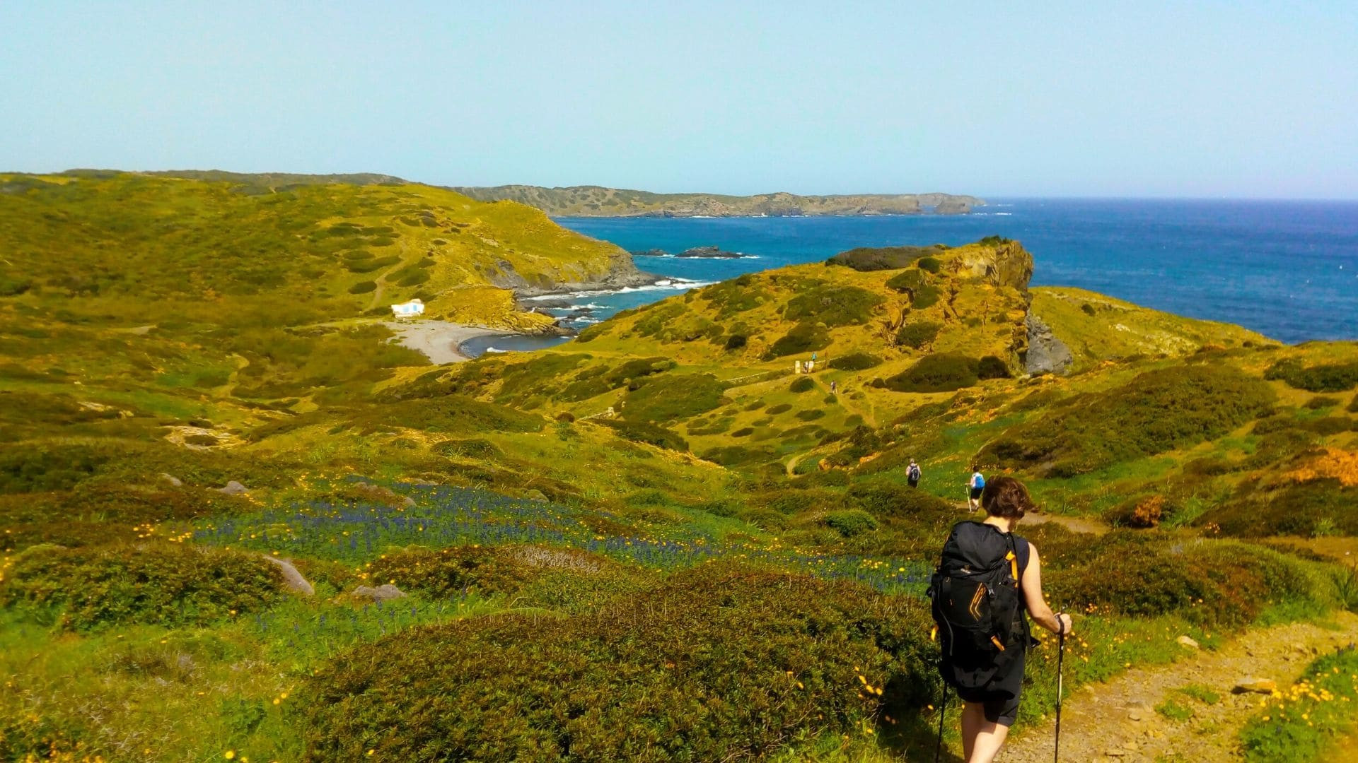 Wanderin auf einem Küstenpfad oberhalb einer Mittelmeerbucht