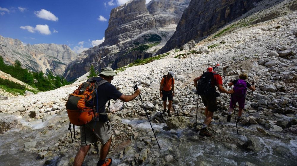 Wanderer überqueren einen Gebirgsbach - Dolomiten - Italien