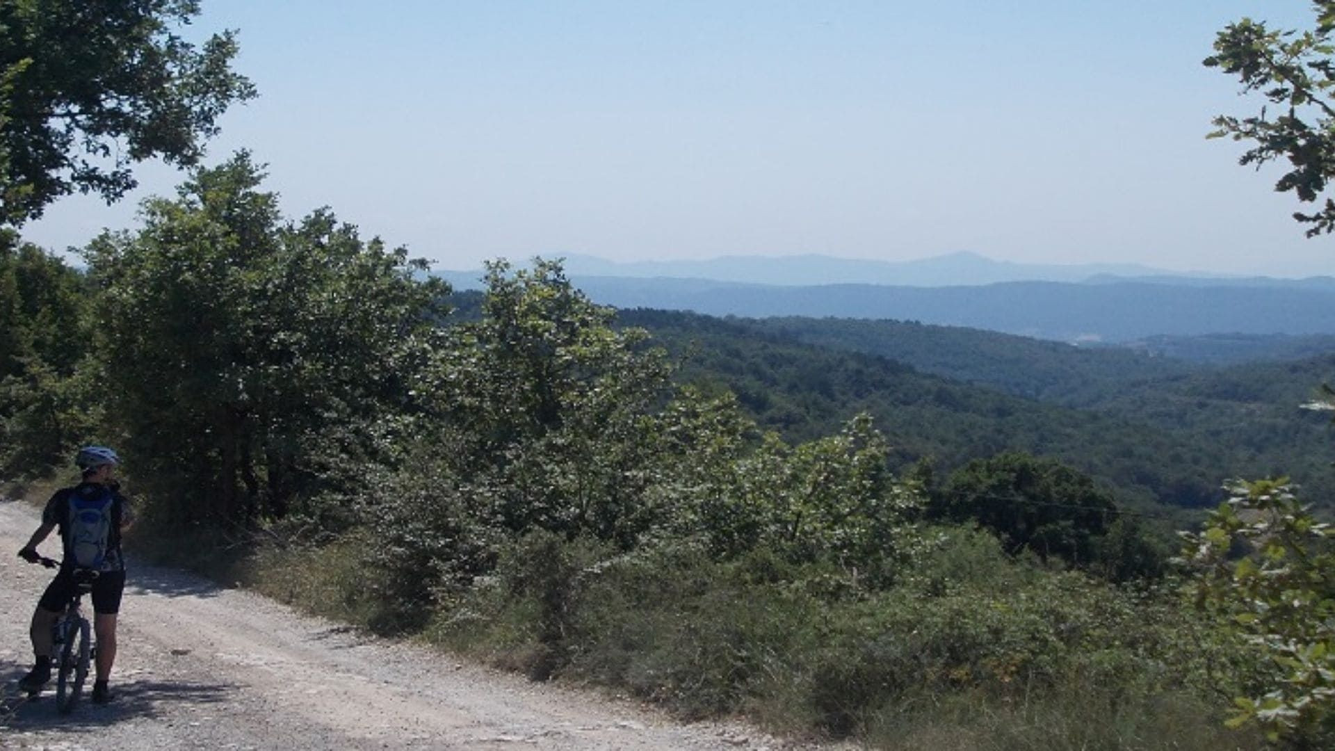 Radfahrer auf einem Weg mit Blick auf bewaldete Hügel - Katalonien - Spanien