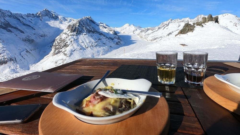 © Oriane Tempé Essenspause auf einer Terrasse mit Blick auf den Aletschgletscher - Wallis - Schweiz