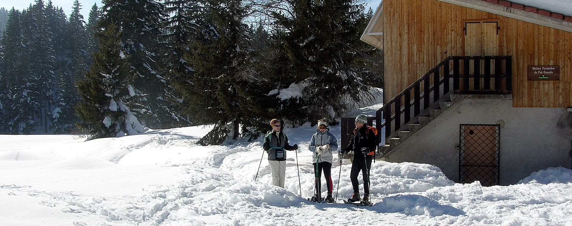 Schneeschuhwanderer nahe einem Forsthaus im Winter - Frankreich