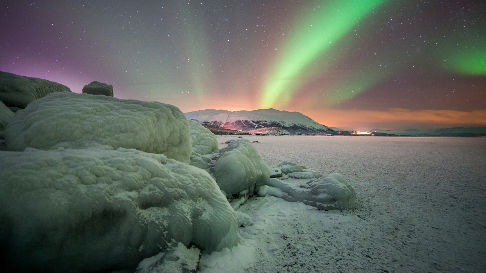 Polarlicht über einem verschneiten, zugefrorenen See - Schweden