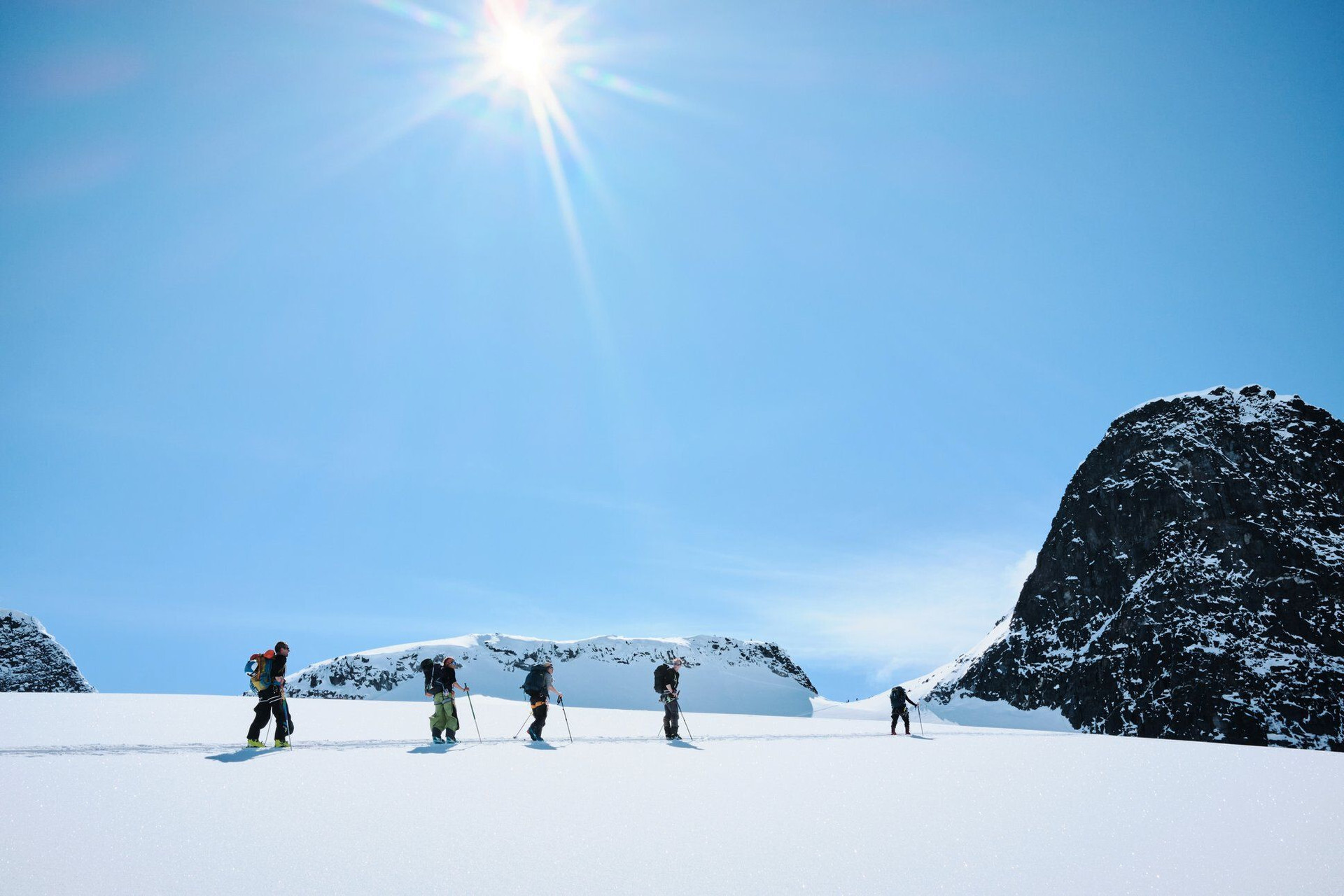 Skitourengruppe beim Aufstieg über ein Schneefeld - Skandinavien
