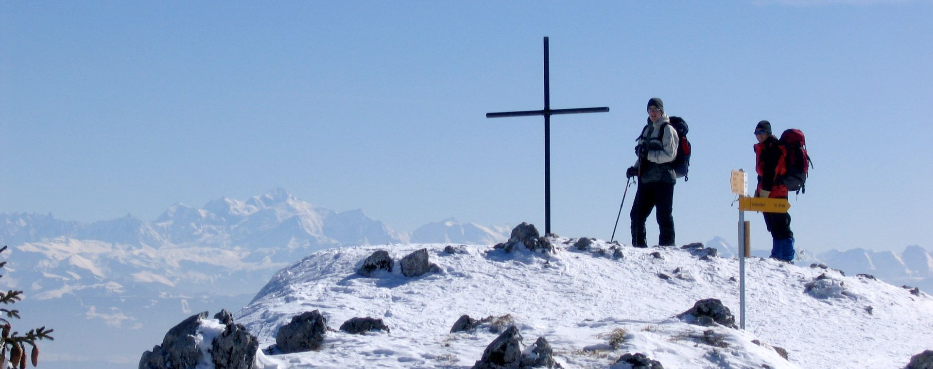 Schneeschuhwanderer nahe einem Gipfelkreuz - Französisch-Schweizer Jura