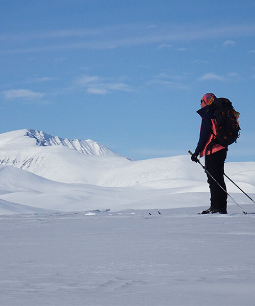 Allein wandernder Skitourengeher auf einem verschneiten arktischen Plateau