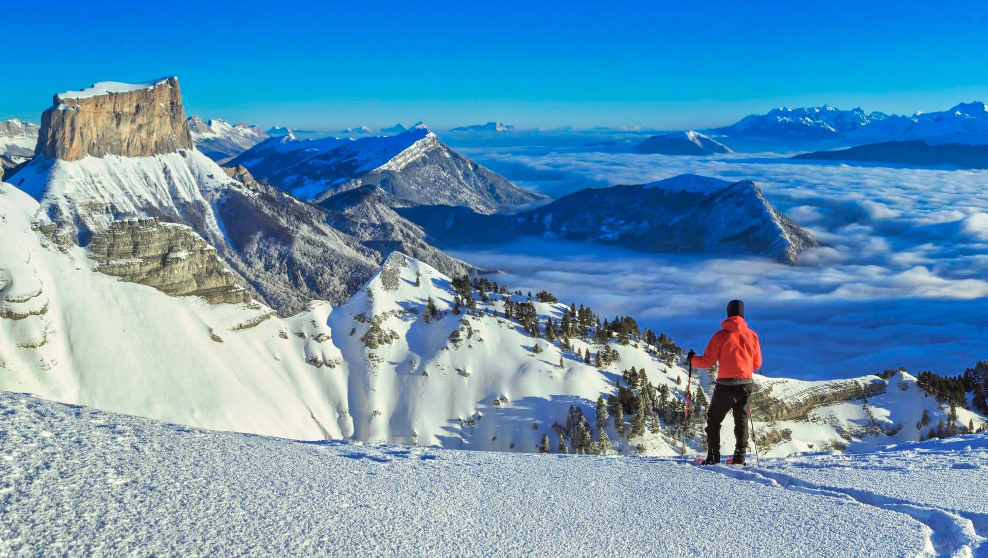 © Adobe Stock Schneeschuhwanderer vor dem Mont Aiguille und einem Wolkenmeer - Vercors - Frankreich